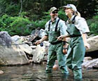 man and woman fishing wearing waders